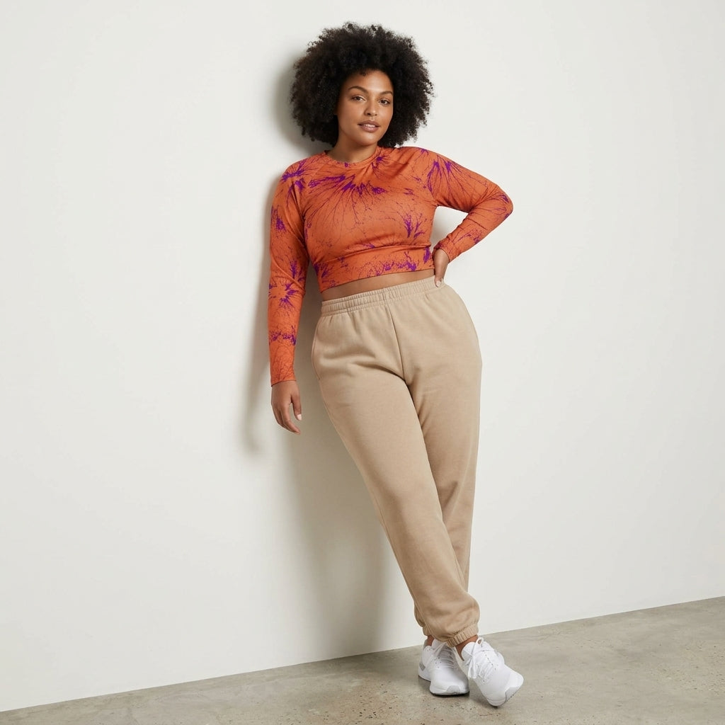 Model leaning against studio wall in Admire Orange Purple Wing crop top