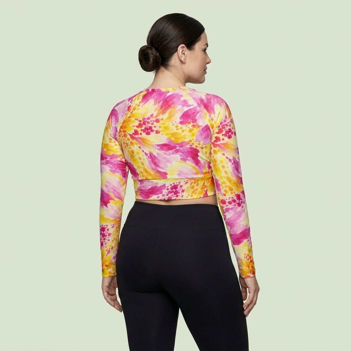 Model wearing Labyrinth Dahlia print long-sleeve crop top, posing in activewear