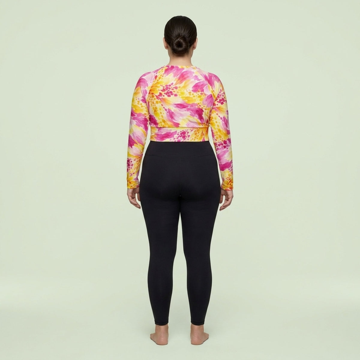 Model wearing Labyrinth Dahlia print long-sleeve crop top in a studio setting